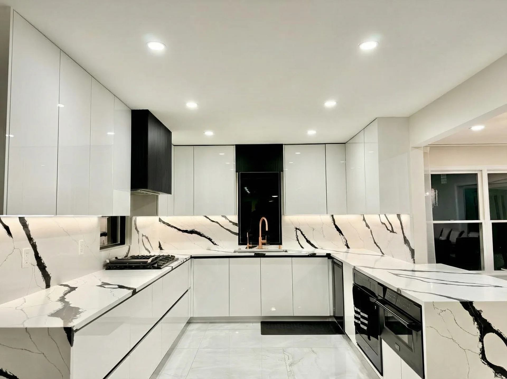 Gloss white cabinetry around the cooking and sink areas
