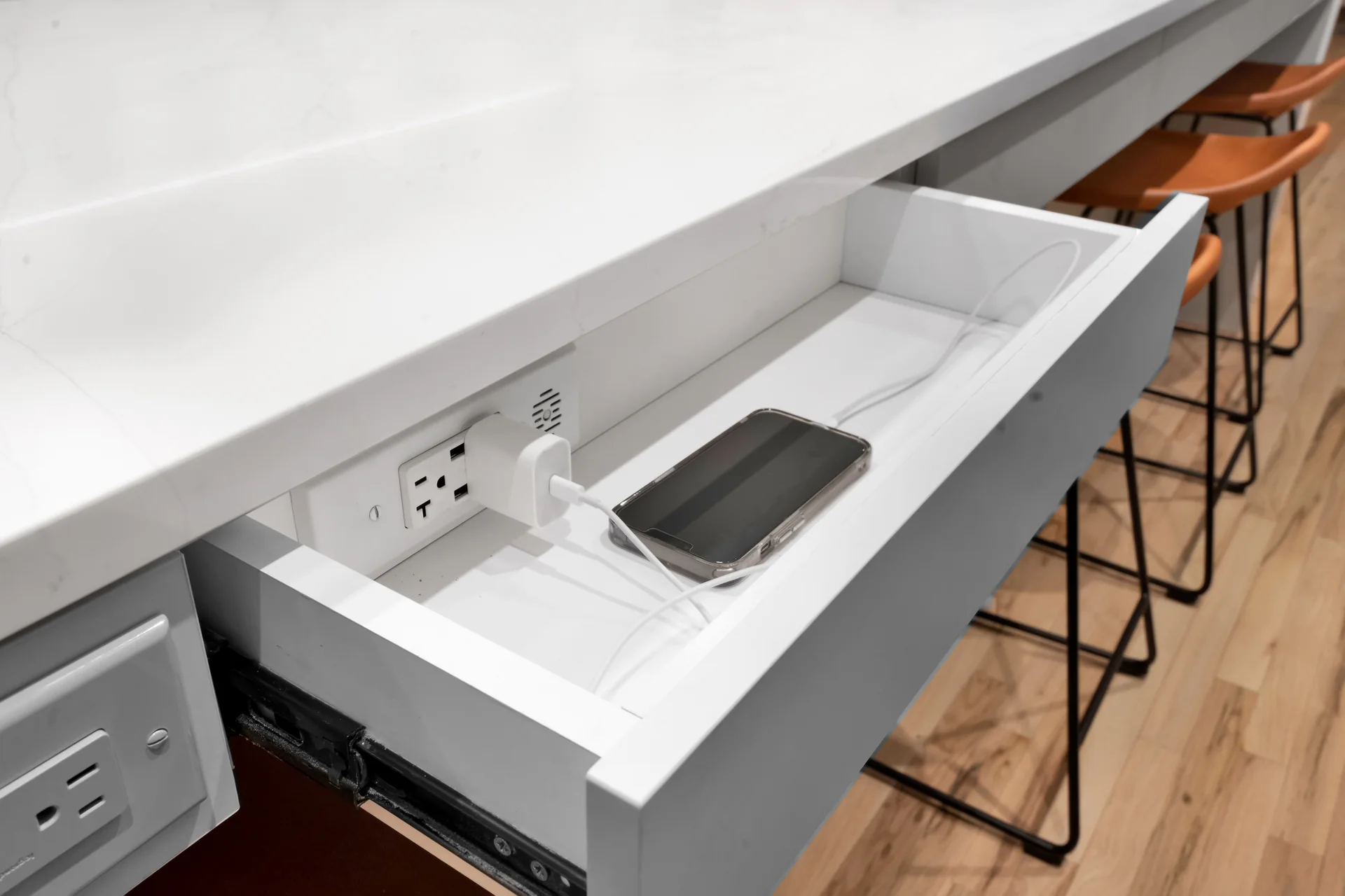 Open island drawer containing an electrical outlet and a phone