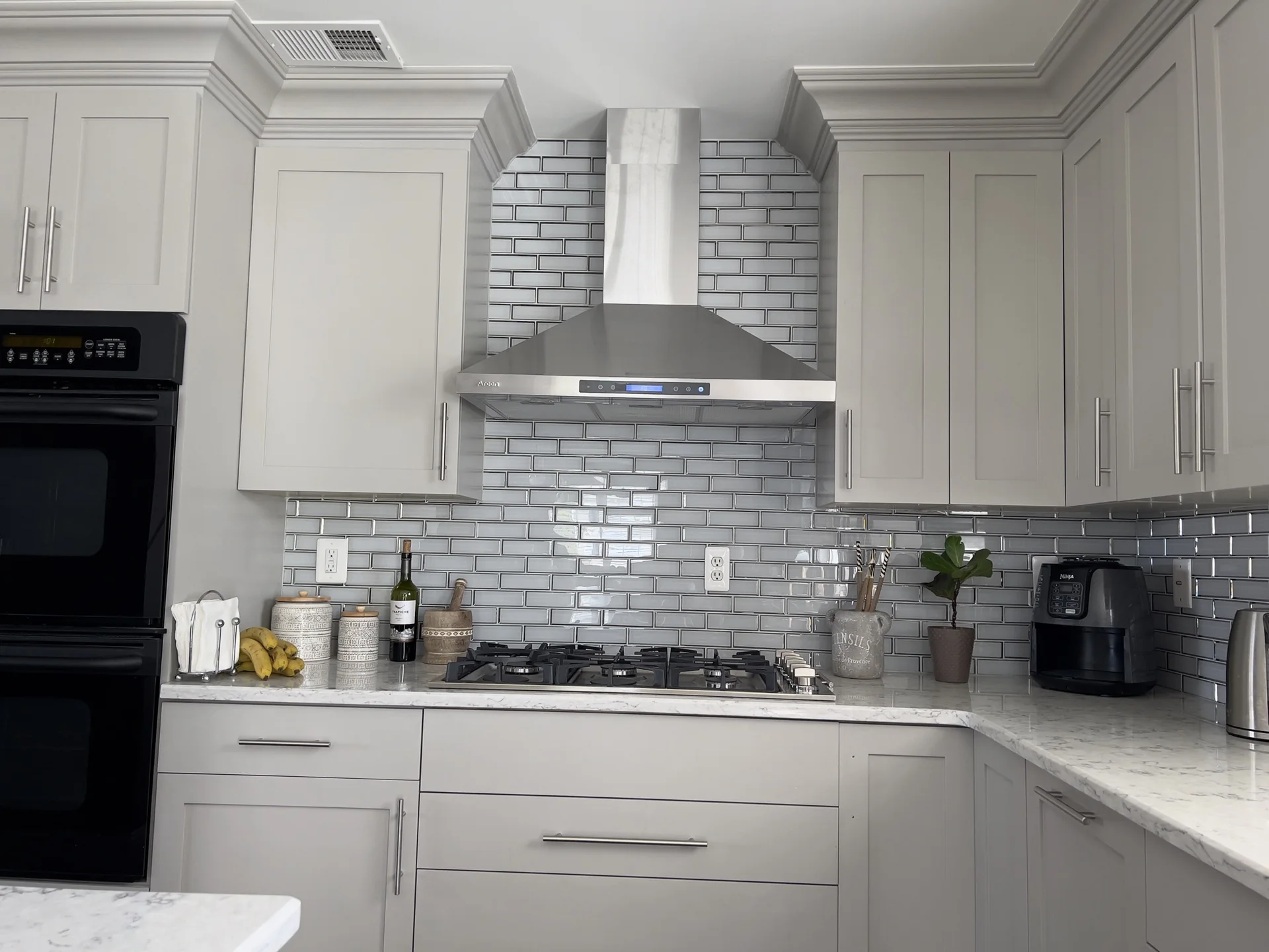 Grey kitchen drawers, metallic tile backsplash and range hood