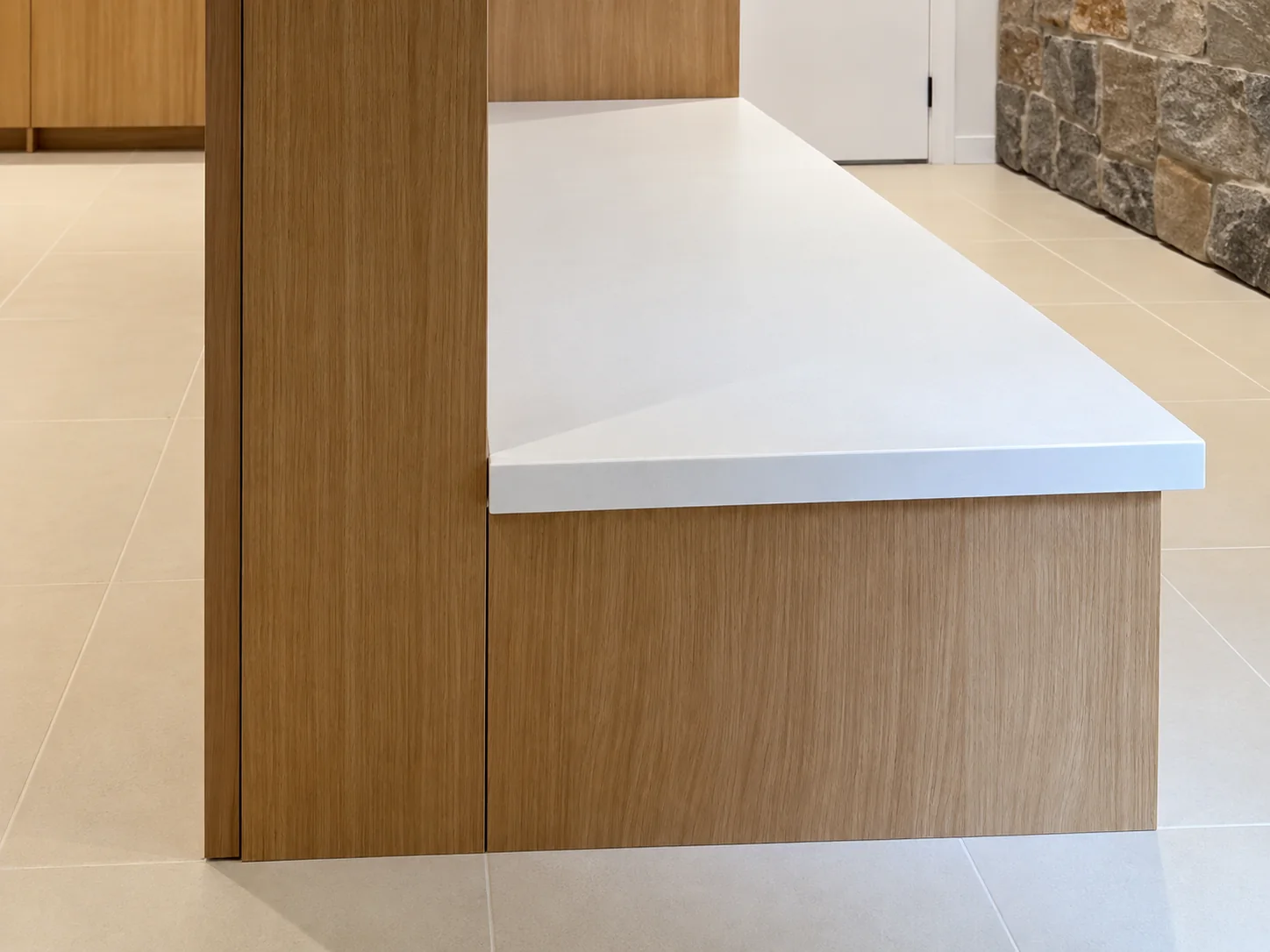 Close detail of the white counter meeting the wood-clad column and base